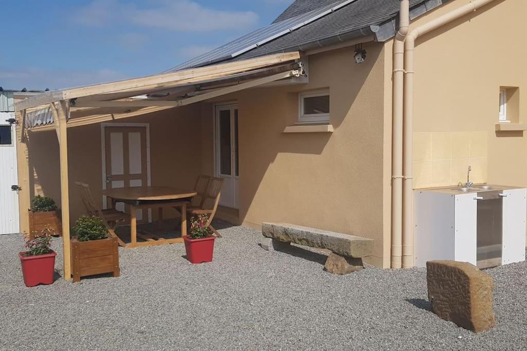 a patio of a house with a table and a bench at Le Mimosa, maison de vacances in Trans-la-Forêt