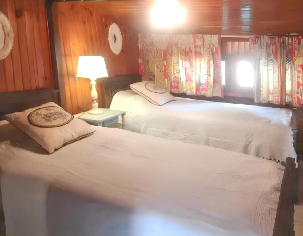 ein Schlafzimmer mit 2 Betten und einem Tisch mit einer Lampe in der Unterkunft Maison de 3 chambres avec jardin clos et wifi a Vendays Montalivet a 7 km de la plage in Vendays-Montalivet
