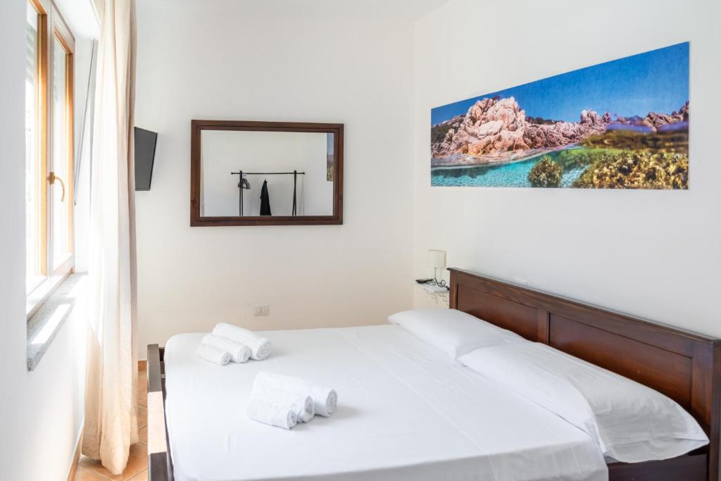 a bedroom with two beds and a mirror on the wall at Appartamenti Le Vele in La Maddalena