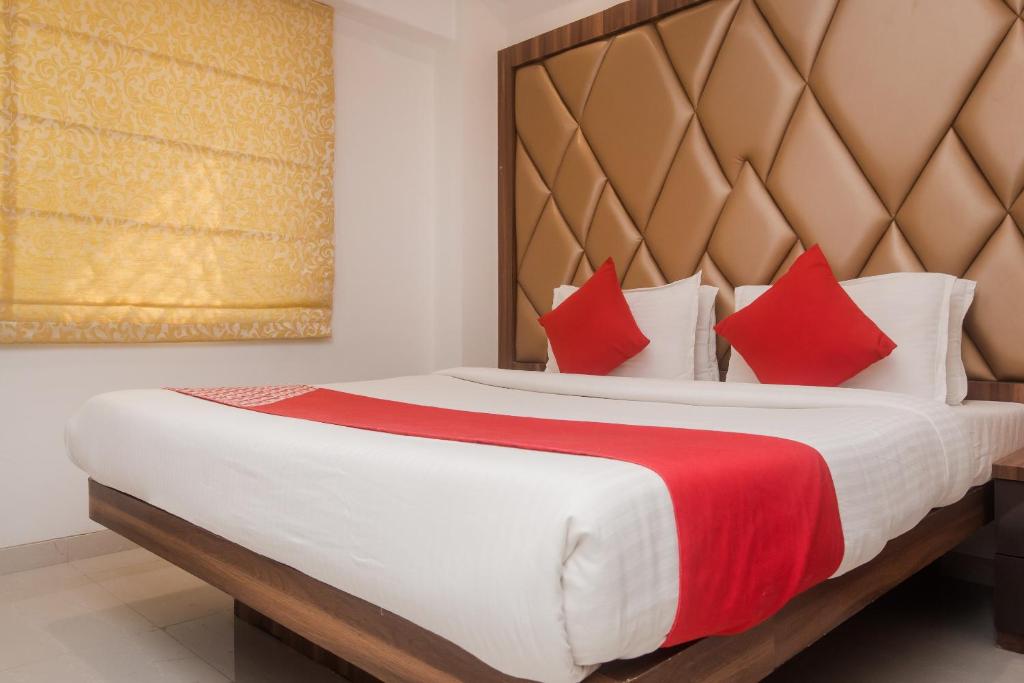 - une chambre avec un grand lit et des oreillers rouges dans l'établissement OYO Flagship Hotel Park Palace, à Mumbai