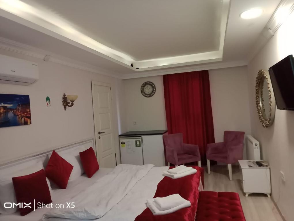 ein Hotelzimmer mit einem Bett und roten Stühlen in der Unterkunft ÇARŞI HOTEL&CAFE in Trabzon