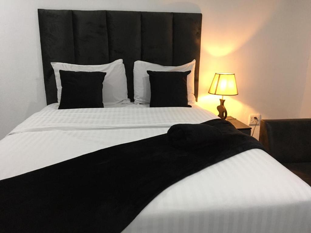 1 dormitorio con 1 cama blanca grande y cabecero negro en De Bliss Lodge en Johannesburgo
