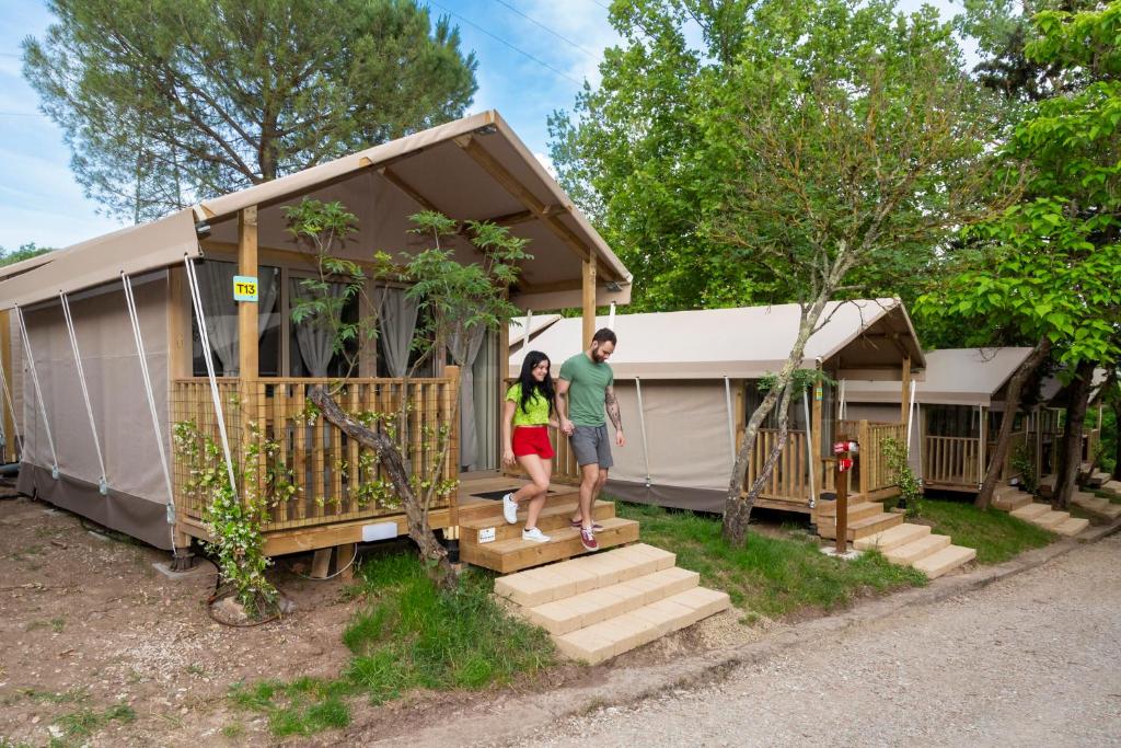 a man and a woman standing in front of a house at hu Firenze Certosa camping in town in Impruneta