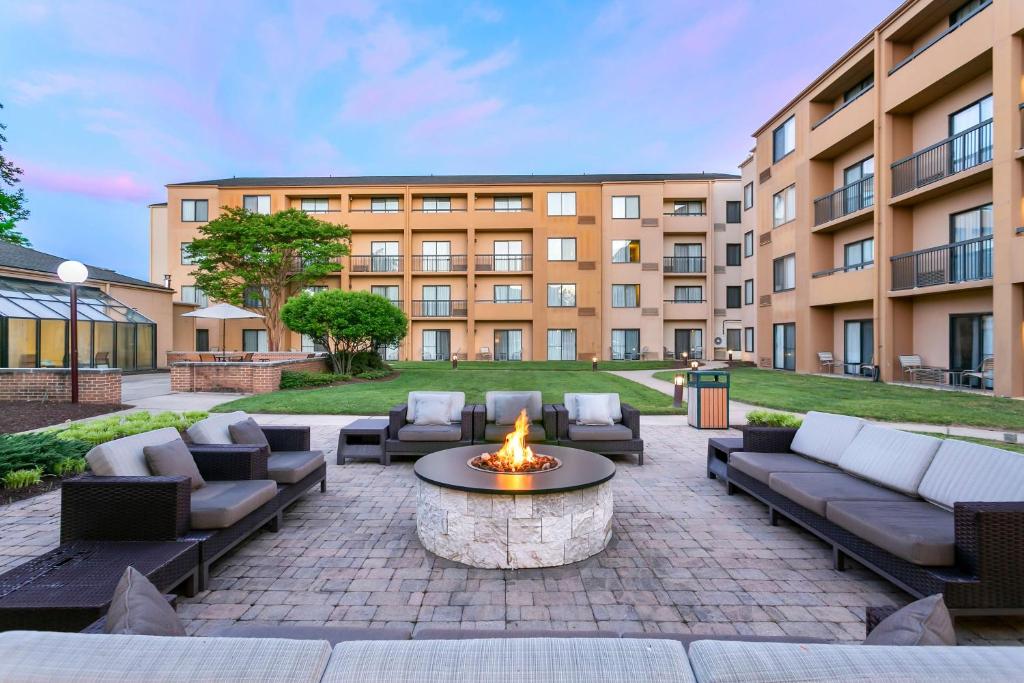 a patio with couches and a fire pit in front of a building at Sonesta Select Greenbelt College Park in Greenbelt