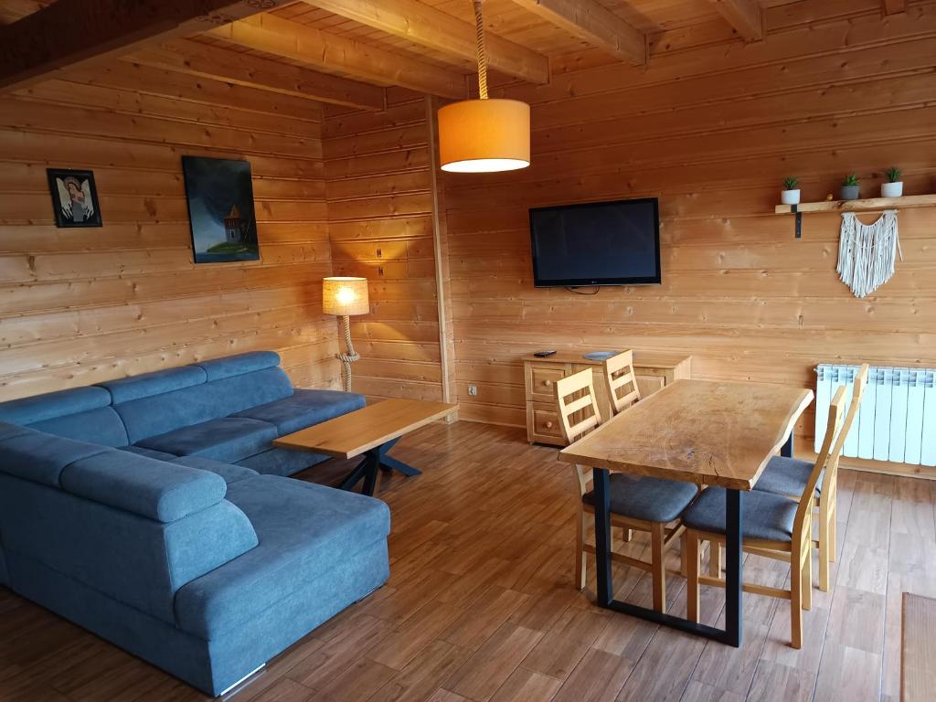 a living room with a blue couch and a table at Katilux willa in Nowy Targ