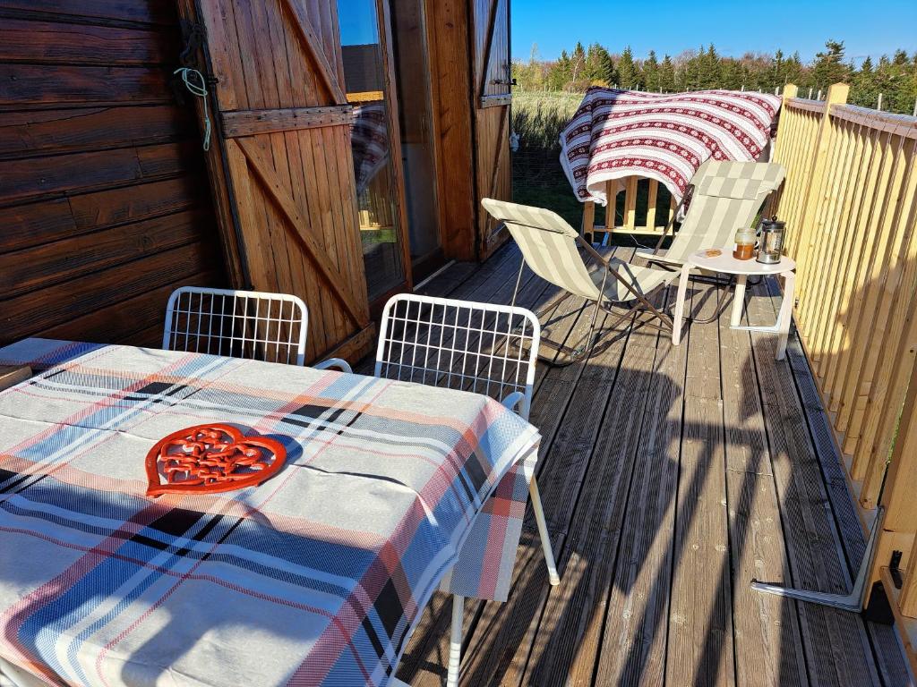 a patio with a table and chairs on a deck at Chalet en bois tout confort in Valleraugue