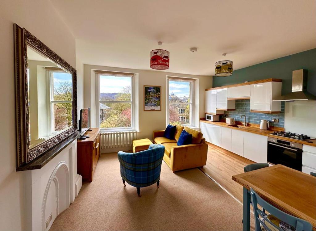 a kitchen and living room with a couch and a table at Opera View by Together Travel - Stylish 2-Bedroom Apartment in Buxton
