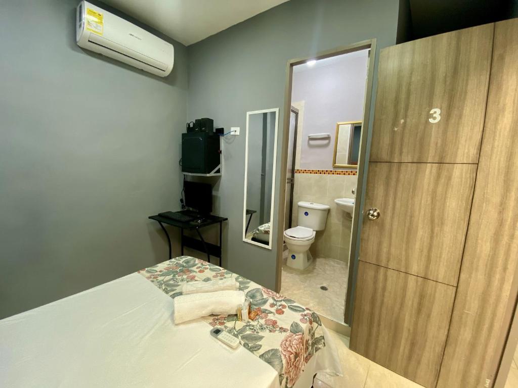 Zimmer mit einem Bett und einem Bad mit einem Spiegel in der Unterkunft Casa Mango in Cali