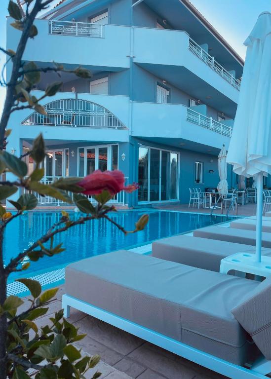 una donna sdraiata su un letto accanto alla piscina di Zante Pantheon Hotel a Tsilivi