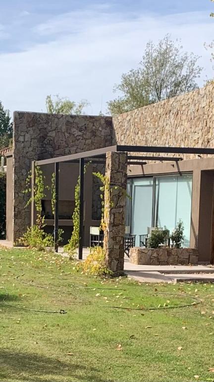 a house with a large window and a grass yard at Chacras House in Chacras de Coria