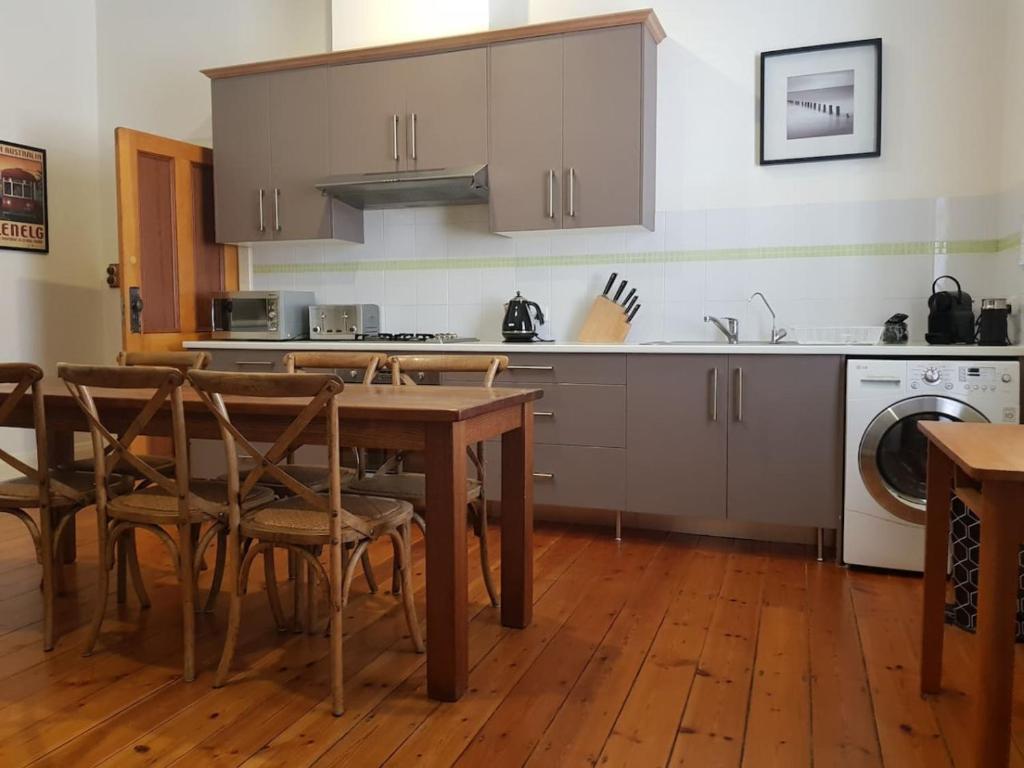 格莱内尔格The Heritage - located in in the center of Glenelg的配有桌椅和水槽的厨房