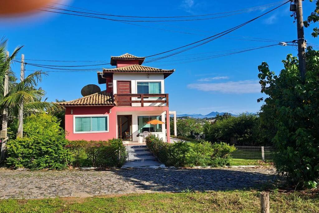 une maison rose avec une tour au sommet dans l'établissement casa perfeita de sonho e completa, à Armacao dos Buzios