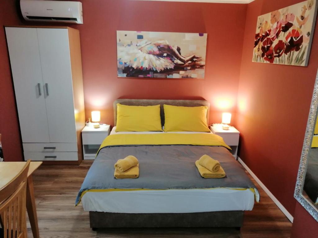 a bedroom with orange walls and a bed with yellow pillows at City Break Apartment in Zagreb