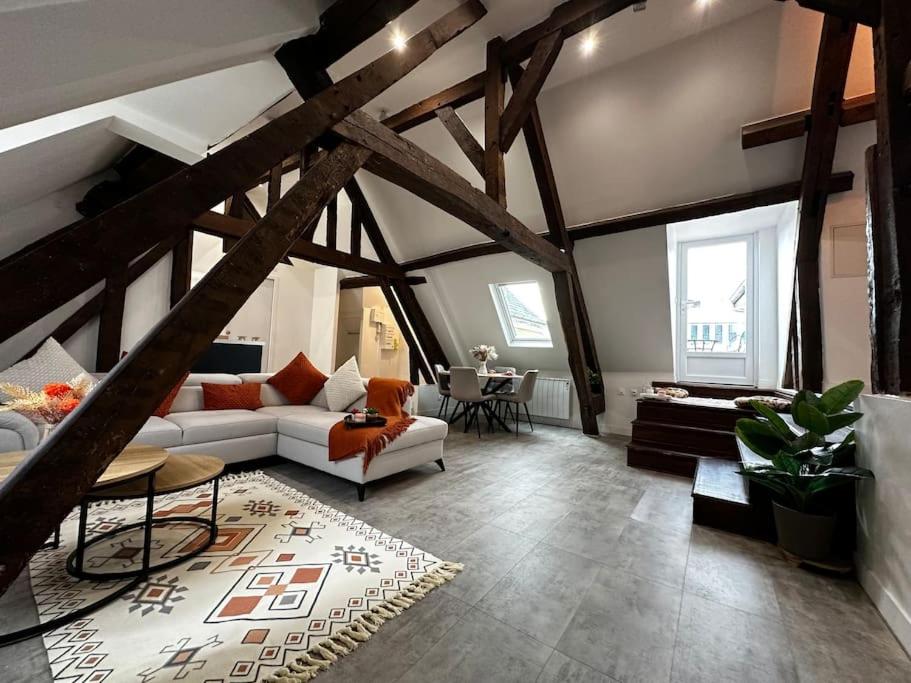 un salon avec un canapé blanc et une table dans l'établissement Charme, poutres et élégance, à Chartres