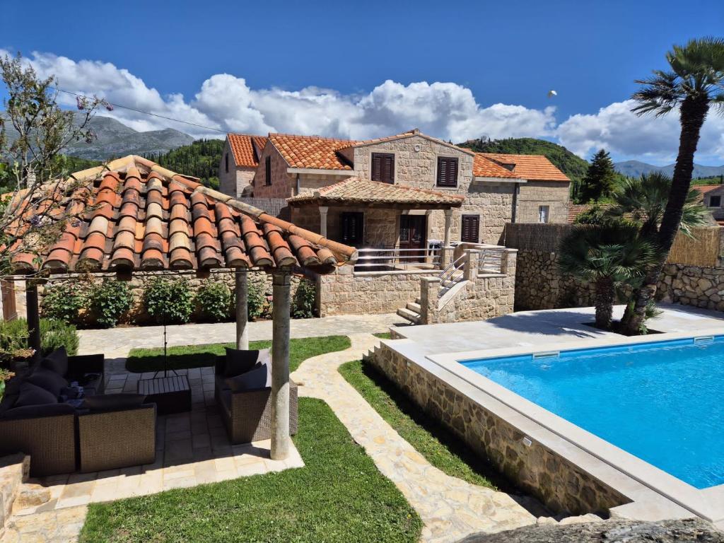 a villa with a swimming pool and a house at Villa Guardian in Čilipi