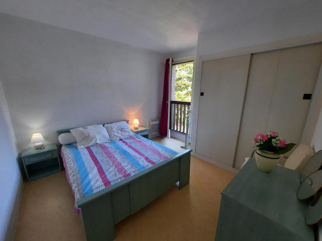 niewielka sypialnia z łóżkiem i balkonem w obiekcie Appartement Lumineux à Seignosse, Proche Plage, Commerces et Activités, Parking, Wifi et Balcon - FR-1-239-813 w mieście Seignosse