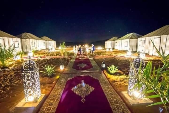 un cortile di notte con luci in un edificio di Luxury Desert Camp Merzouga a Merzouga