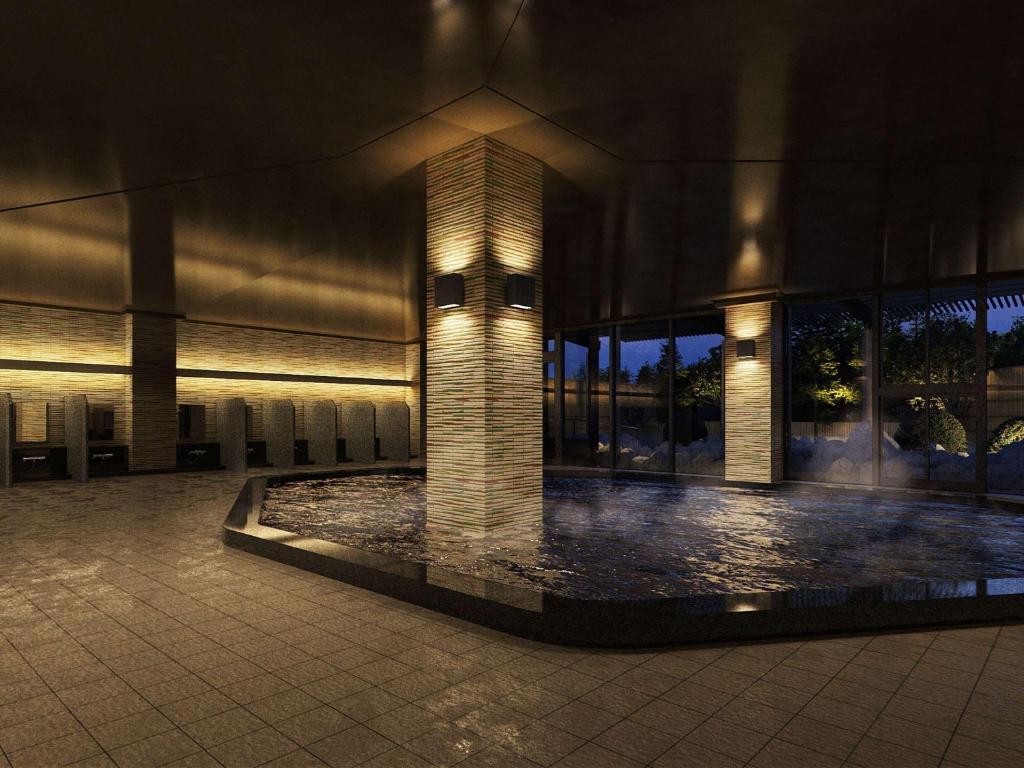 un edificio con una fuente delante de él por la noche en Grand Mercure Ise-shima Resort & Spa, en Shima