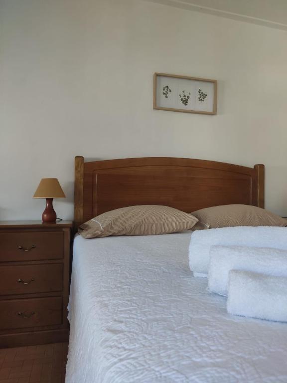 a bed with a wooden headboard and a night stand at AL Vila Lina in Termas de Sao Pedro do Sul