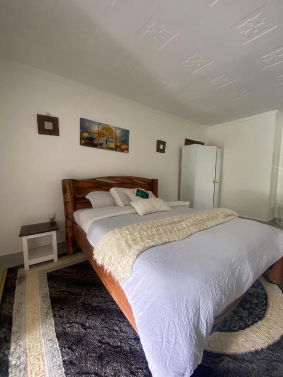 ナイロビにあるUtulivu Houseの白いシーツが敷かれた大きなベッドのある寝室