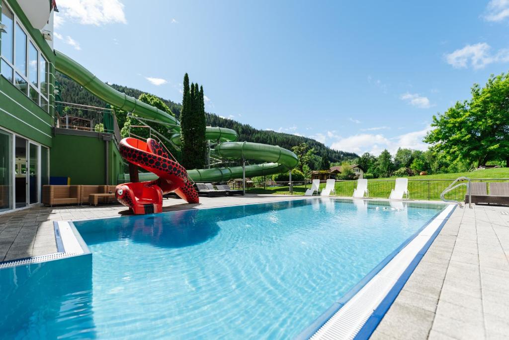 a large swimming pool with a water slide at Familienhotel Trebesingerhof in Trebesing