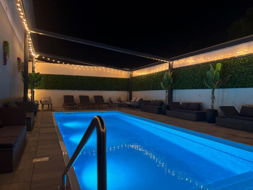 una piscina por la noche con luces alrededor en XXL rooms&spa, en Osijek