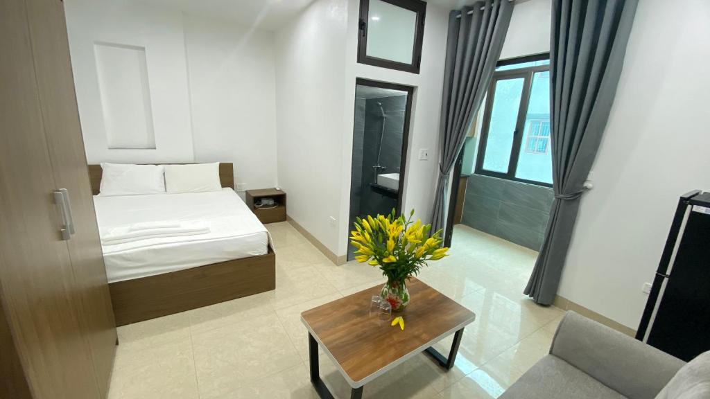 een hotelkamer met een bed en een tafel met bloemen bij Era Apartment Tran Thai Tong in Hanoi