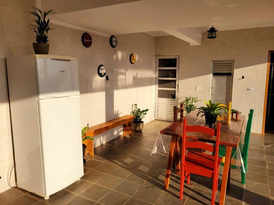eine Küche mit einem Tisch und einem weißen Kühlschrank in der Unterkunft Casa no Centro Próxima ao Thermas Water Park in Águas de São Pedro