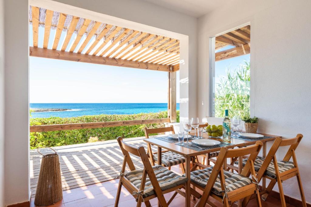 a dining room with a table and a view of the ocean at Mon Palau in Sant Lluis