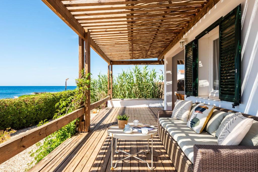 un patio con un divano, un tavolo e l'oceano di Mon Palau a Sant Lluís