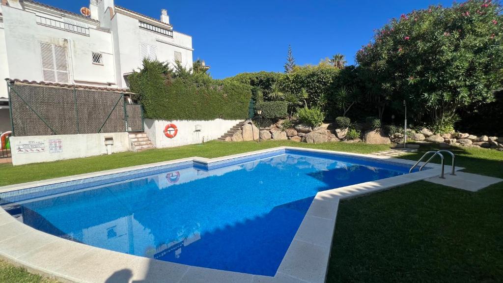 a swimming pool in the yard of a house at Casa Adosada S'Agaró in S'agaro