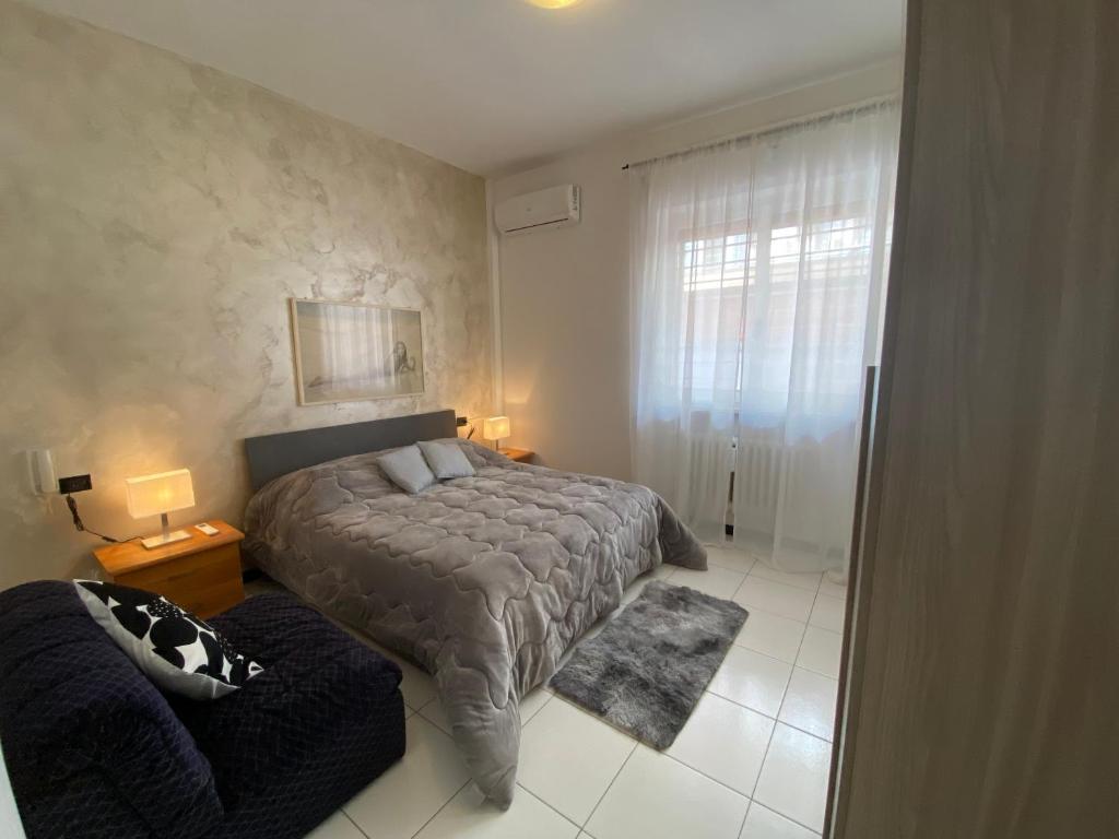 a bedroom with a bed and a couch at The Little House in Pescara