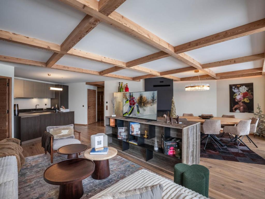 Il comprend un salon doté de plafonds en bois et une salle à manger. dans l'établissement Luxueux Appartement Neuf à Courchevel 1850 - Ski-in/Ski-out, Piscine, Spa, 3 Chambres + Coin Montagne - FR-1-564-110, à Courchevel