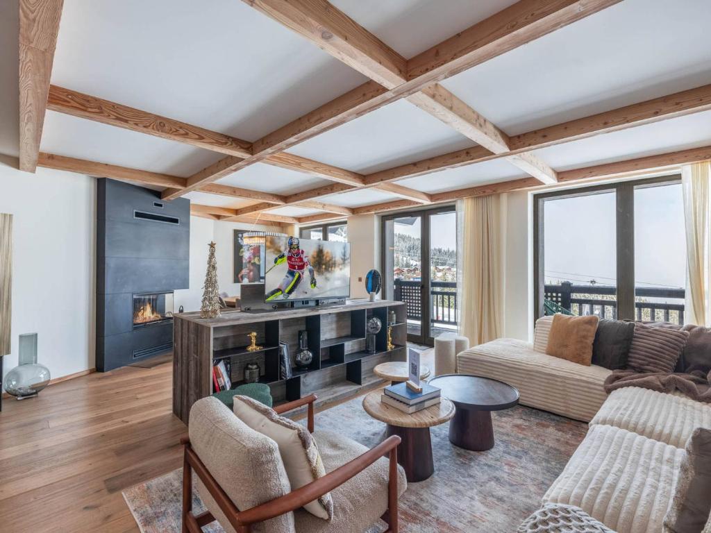 un salon avec un canapé et une cheminée dans l'établissement Duplex neuf à Courchevel 1850, au pied des pistes avec accès piscine et SPA - FR-1-564-101, à Courchevel