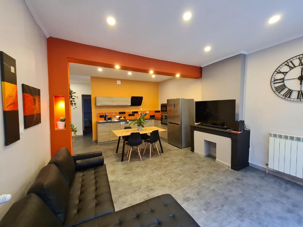 un salon avec un canapé et une table et une cuisine dans l'établissement Magnifique appartement moderne hyper centre, à Saint-Étienne