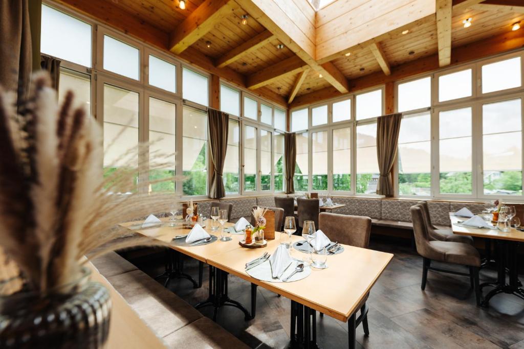 a dining room with tables and chairs and windows at Familienhotel Trebesingerhof in Trebesing