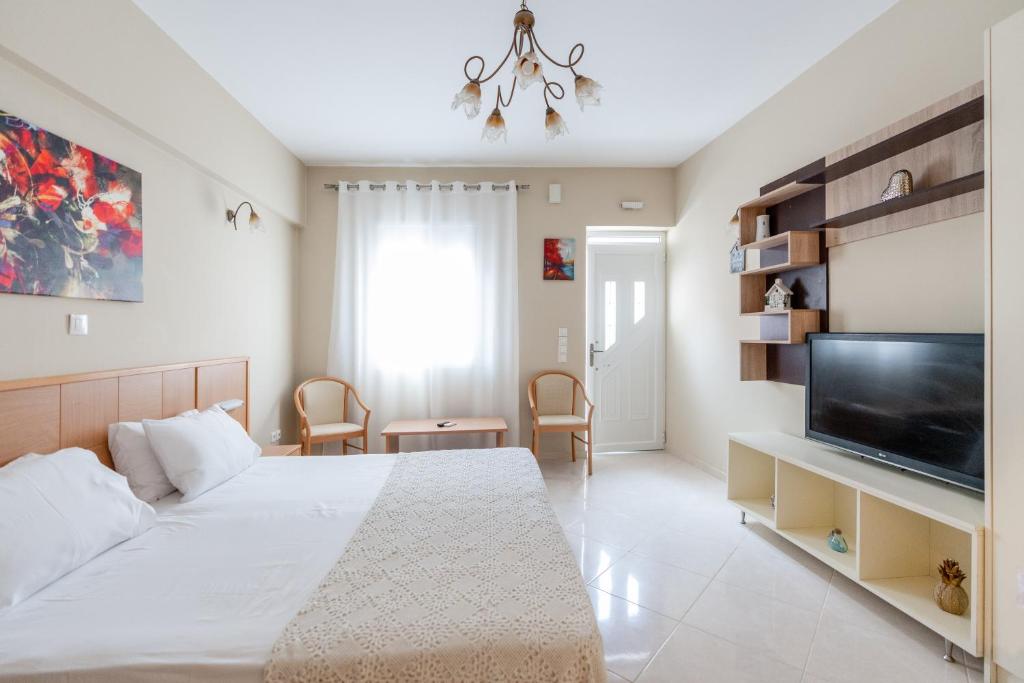 sypialnia z łóżkiem i telewizorem z płaskim ekranem w obiekcie Romeo apartament 2 w Lixoúrion
