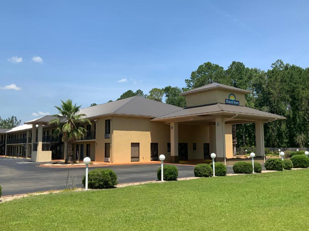 a hotel building with a lawn in front of it at Days Inn by Wyndham Lake City I-10 in Lake City