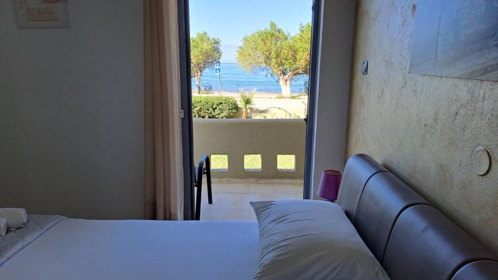 a bedroom with a bed and a view of the ocean at Galini Beach in Plakias