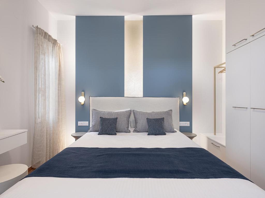 sypialnia z dużym białym łóżkiem z niebieskimi ścianami w obiekcie Elena Apartments w mieście Almirida