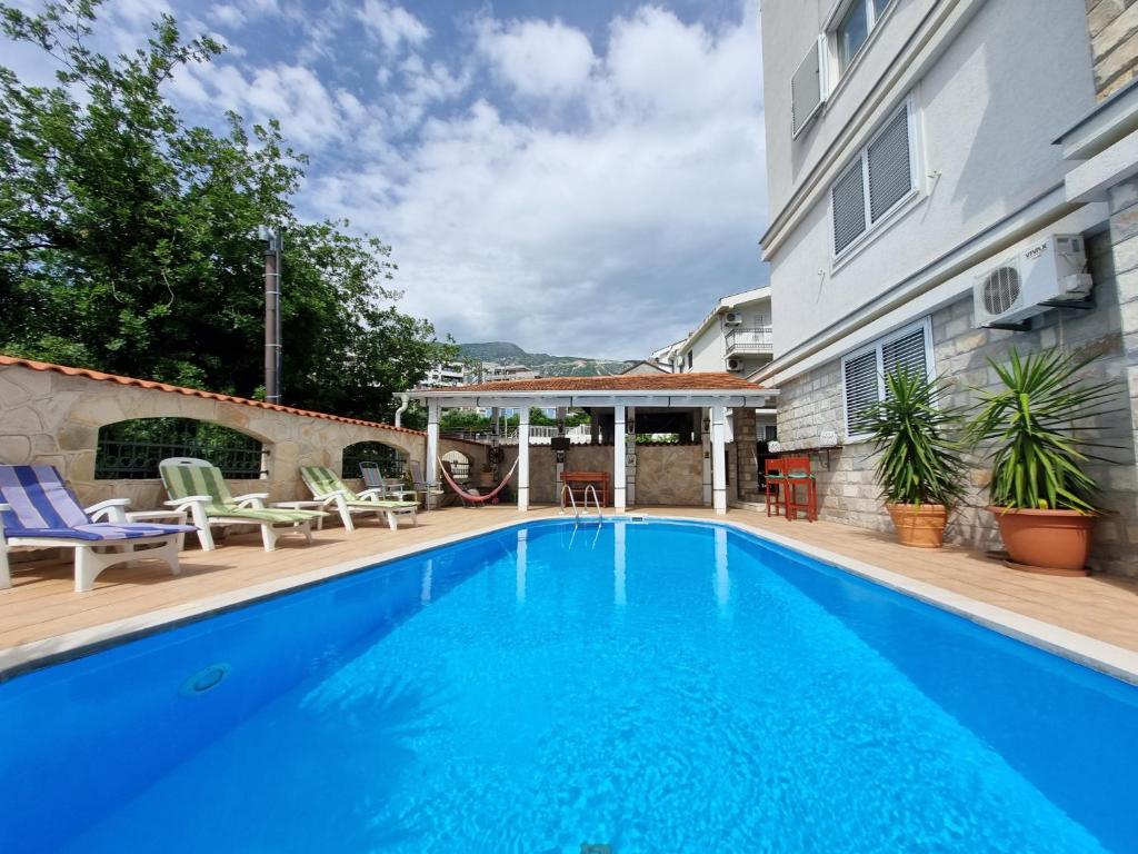 una grande piscina blu accanto a un edificio di Mila & Aleksandr Apartments a Budua