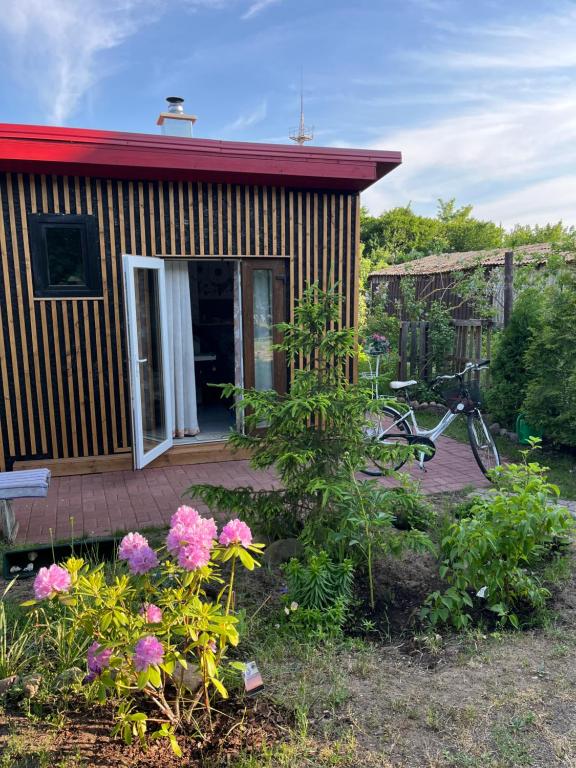 una pequeña casa con una bicicleta estacionada frente a ella en Atpūtas vieta ar pirti en Ventspils