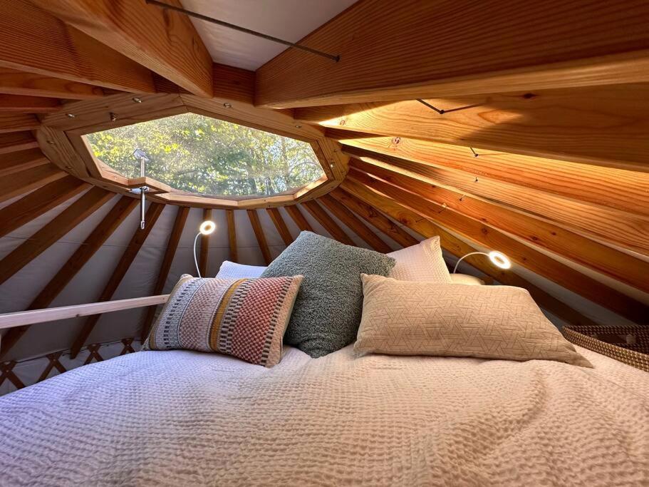 a bed in a tiny house with a window at Purple City Retreats - Luxury Yurt & Spa in Portland