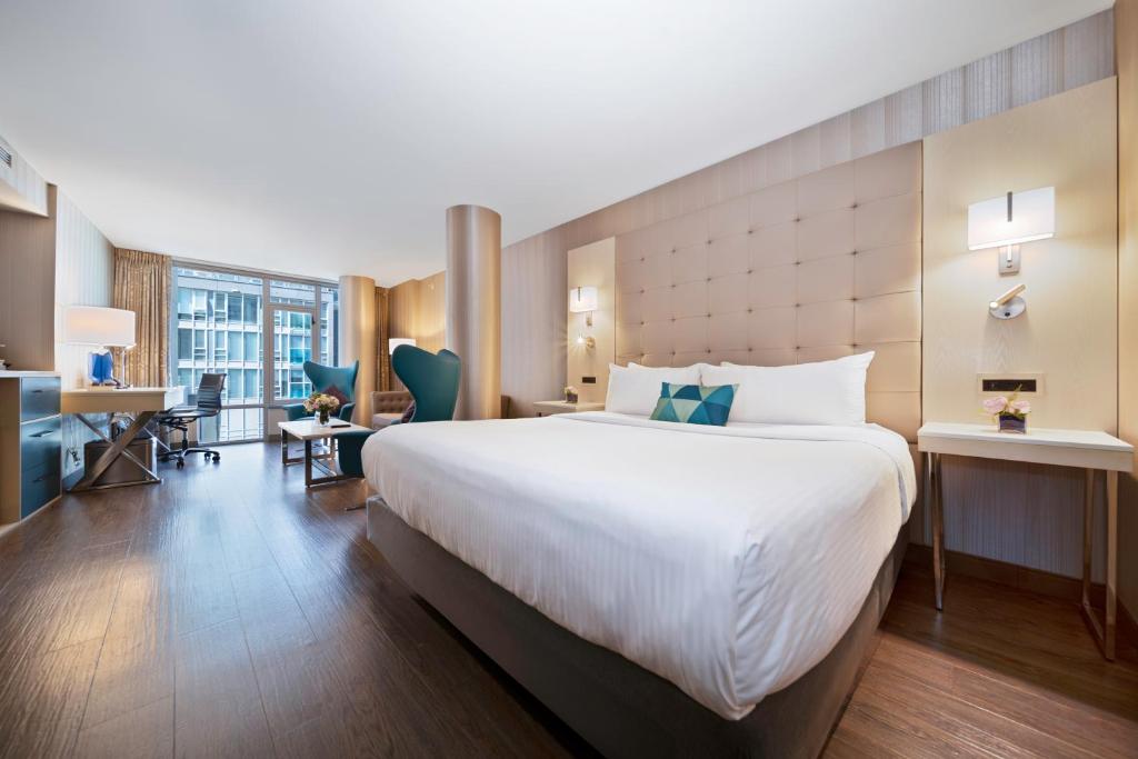 a hotel room with a large bed and a desk at Hotel BLU in Vancouver