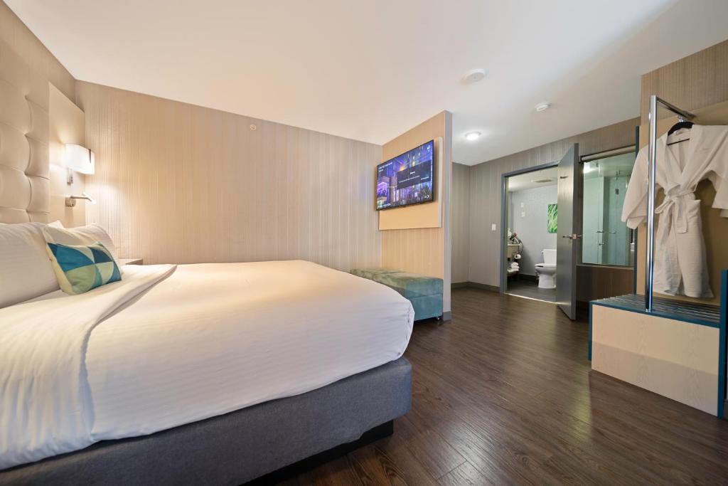 a hotel room with a large bed and a television at Hotel BLU in Vancouver