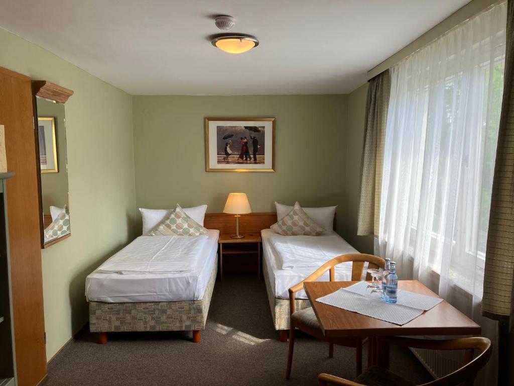 a hotel room with two beds and a table at Villa Dorothea in Heringsdorf