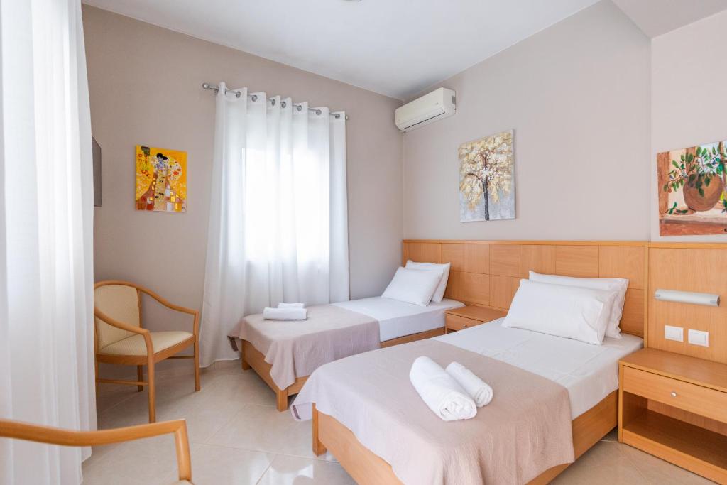 Pokój hotelowy z 2 łóżkami i krzesłem w obiekcie Romeo apartment w Lixoúrion