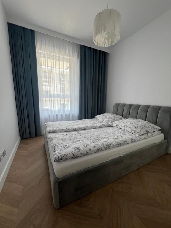 łóżko w sypialni z dużym oknem w obiekcie Tani Nocleg Ełk - Apartament I love Ełk w mieście Ełk