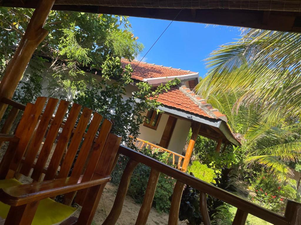 a house with a chair and a palm tree at Prime Surfers Bungalow in Arugam Bay
