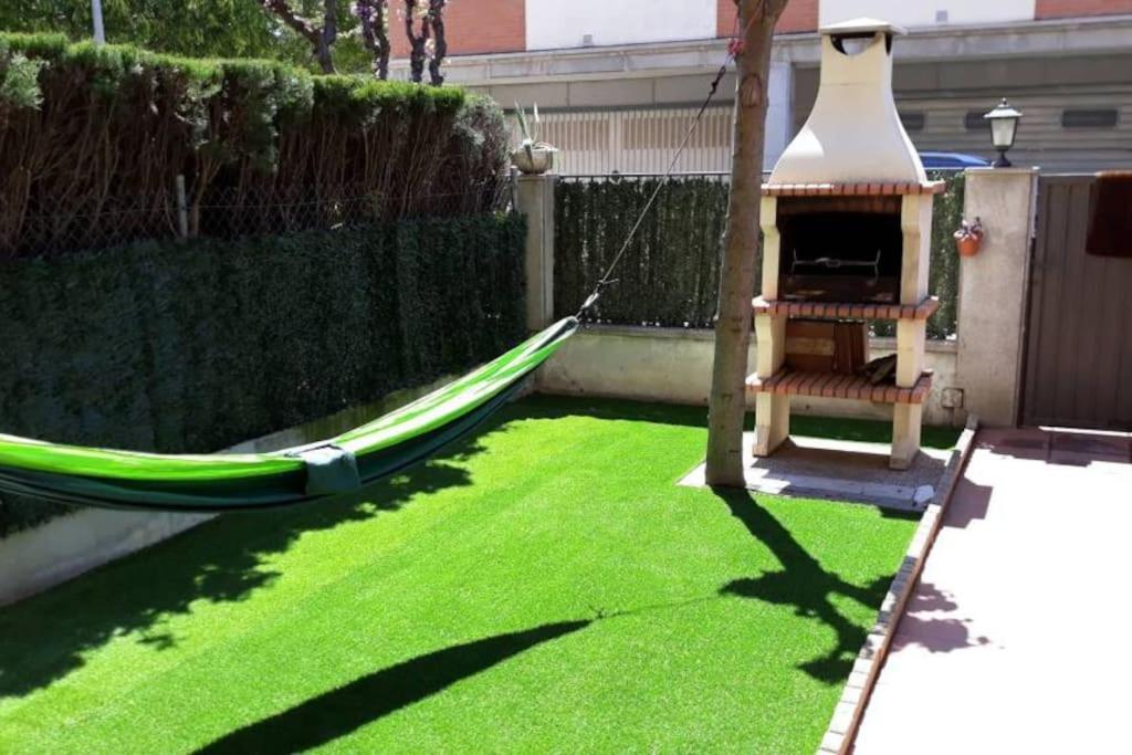 einen Hinterhof mit einer Hängematte und einer Schaukel in der Unterkunft Casa en Malgrat, cerca de la playa in Malgrat de Mar